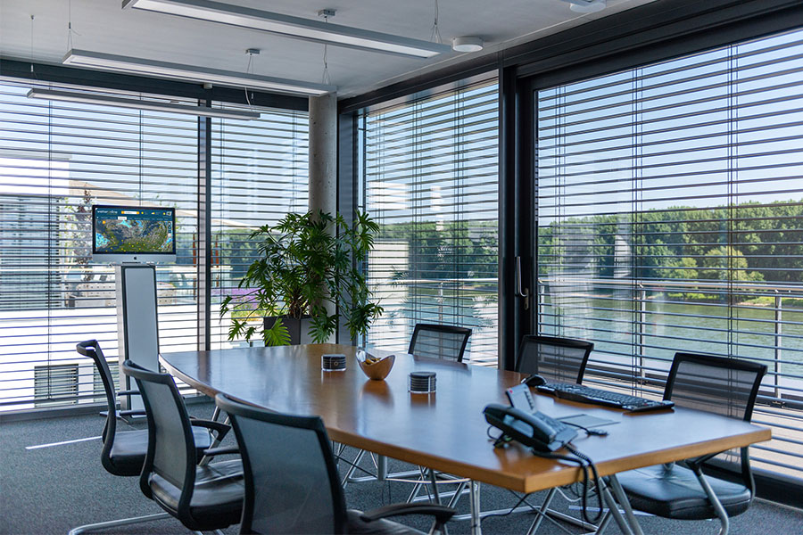 Blick in den großen Konferenzraum, der mit vielen Sitzplätzen und Blick auf den Rhein zum Arbeiten einlädt